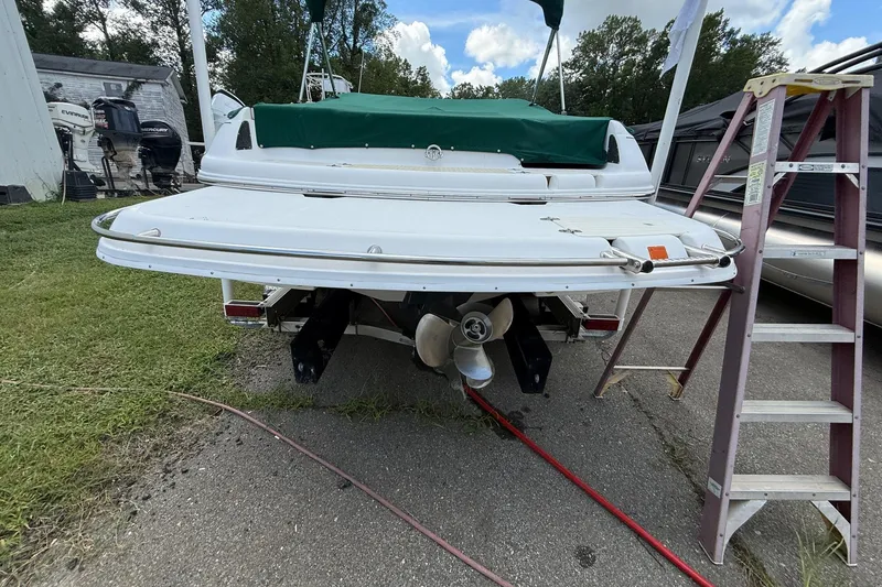 Slide: The Image of 2005 Bryant 214 boat rear view with ladder and green cover. - 4