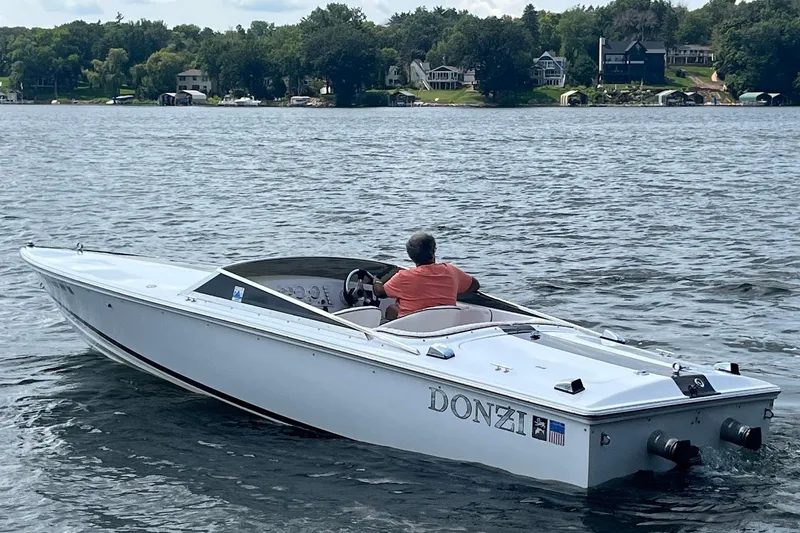 Slide: The Image of 1999 Donzi 22 Classic boat on a lake with scenic shoreline background. - 4