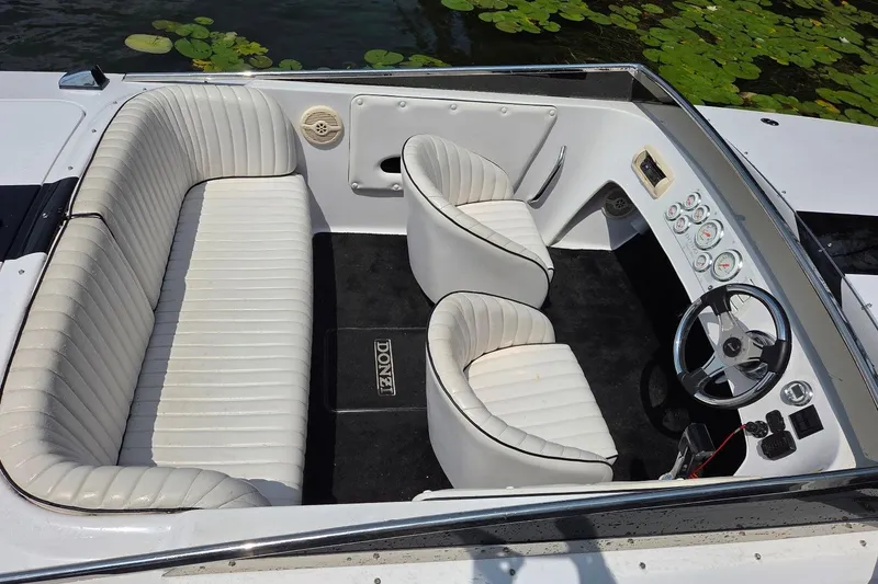 Slide: The Image of Interior of a 1999 Donzi 22 Classic boat with white seating and dashboard. - 6