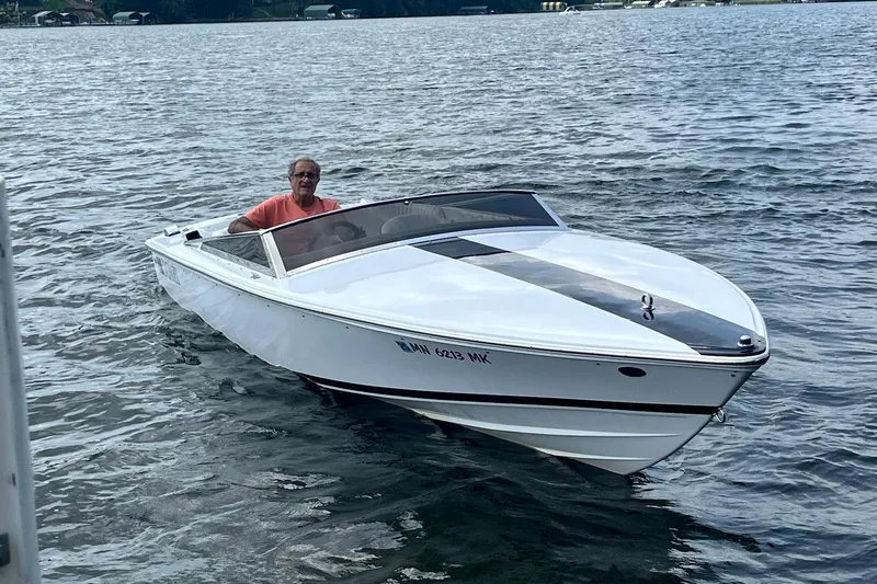 Slide: The Image of 1999 Donzi 22 Classic boat cruising on a lake with a person onboard. - 7