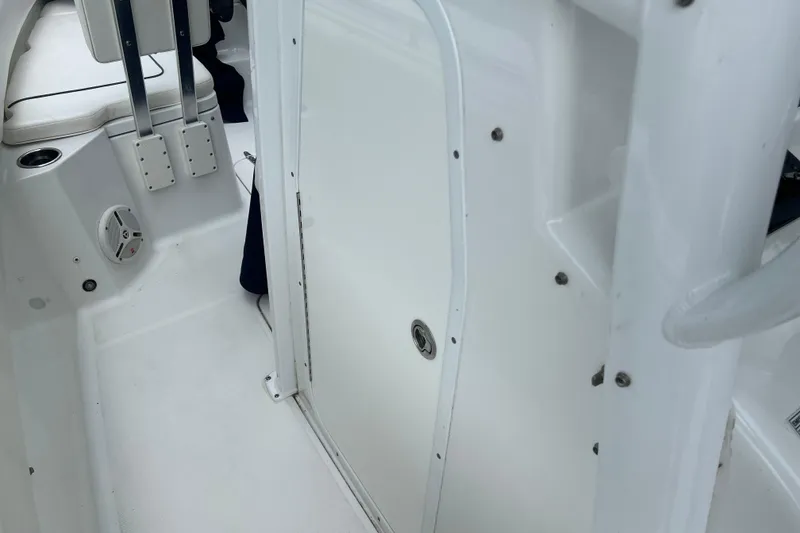 Slide: The Image of 2014 Sea Hunt Gamefish 27 interior with white seating and storage compartment. - 16