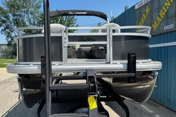 Slide: The Image of 2026 Sun Tracker Bass Buggy 18 DLX pontoon boat on trailer, rear view. - 2