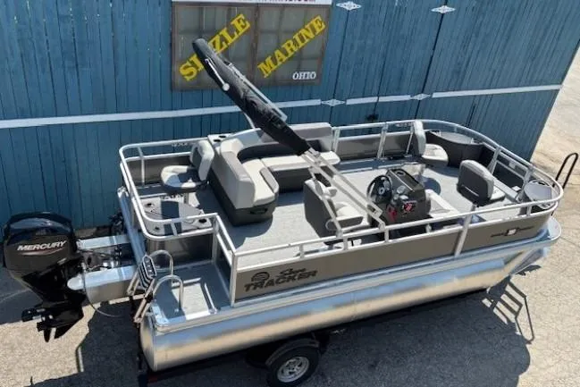 Slide: The Image of 2026 Sun Tracker Bass Buggy 18 DLX pontoon boat with Mercury engine, docked at Sizzle Marine. - 6