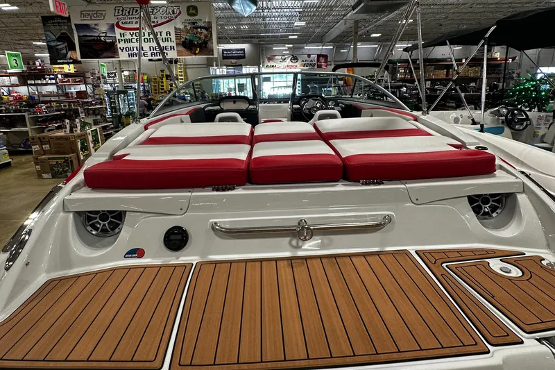 Slide: The Image of 2024 Crownline 200SS boat with red and white seating, displayed in a showroom. - 5