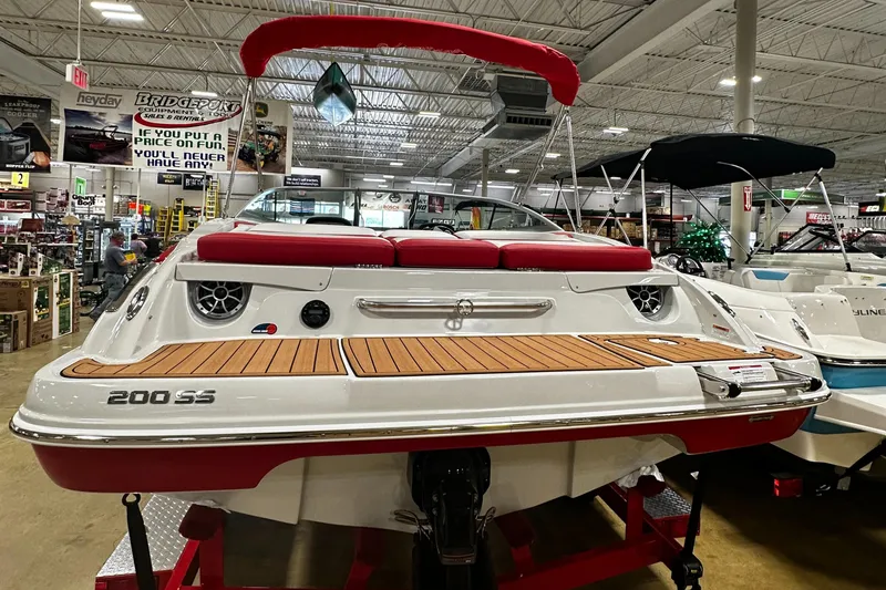 Slide: The Image of 2024 Crownline 200SS boat on display in a showroom, rear view. - 6