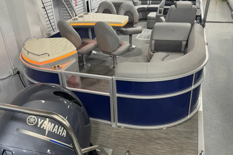 Slide: The Image of 2020 Bennington 23 SXPD pontoon boat interior with Yamaha engine, featuring plush seating and table. - 24
