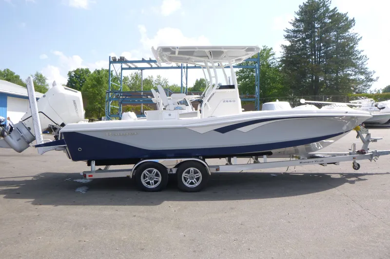 The Image of 2024 Ranger 2660 Bay boat on trailer, parked outdoors, with dual engines. - 1
