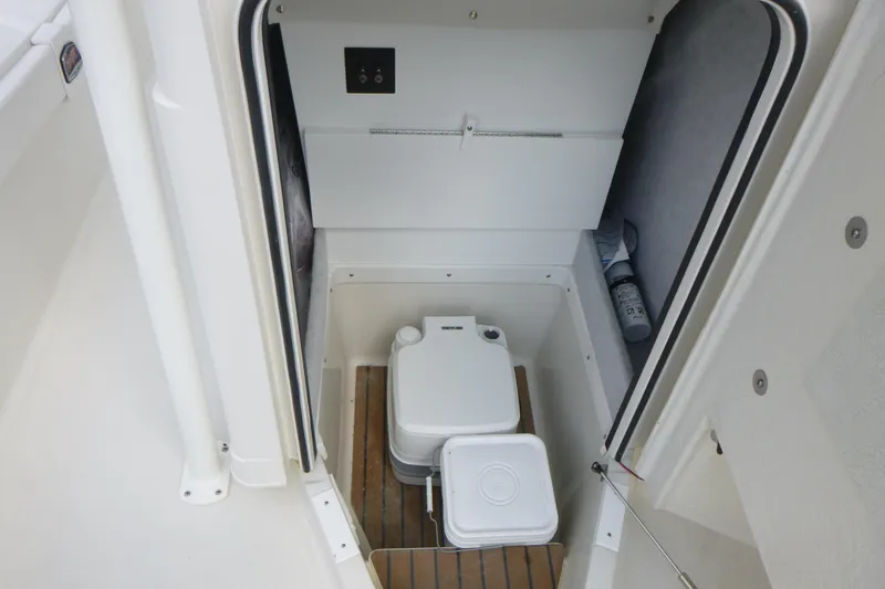 Slide: The Image of 2024 Ranger 2660 Bay boat interior storage compartment with portable toilet. - 10