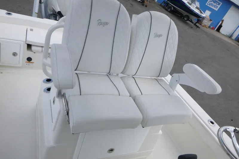 Slide: The Image of 2024 Ranger 2660 Bay boat with white cushioned seating and armrests. - 12