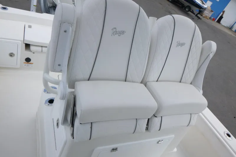 Slide: The Image of 2024 Ranger 2660 Bay boat with luxurious white seating and embroidered logos. - 13
