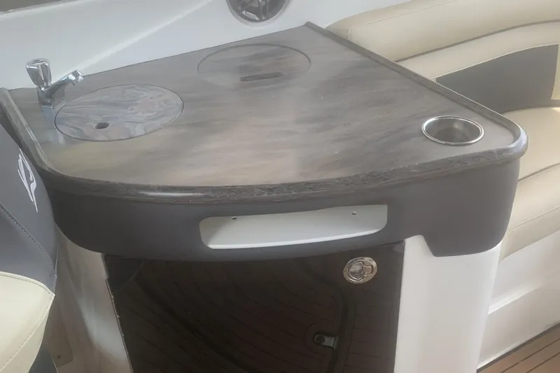 Slide: The Image of Interior of a 2019 Rinker 29 QX boat featuring a compact kitchenette with sink. - 13