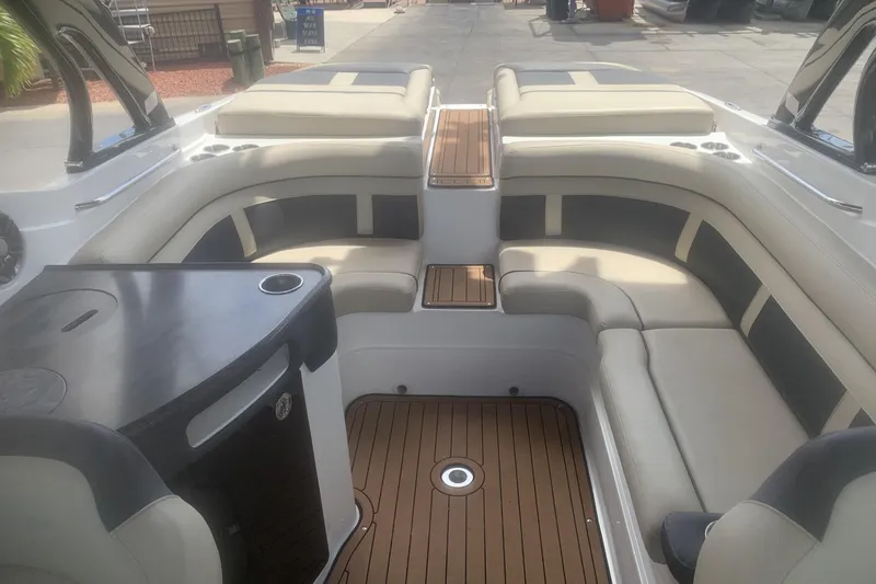 Slide: The Image of 2019 Rinker 29 QX boat interior with beige seating and wood accents. - 14