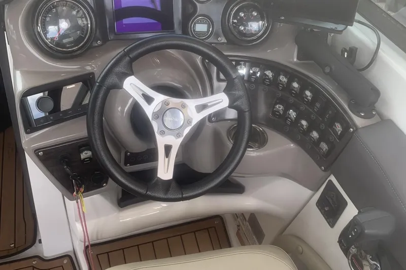 Slide: The Image of 2019 Rinker 29 QX boat dashboard with steering wheel and control panel. - 2