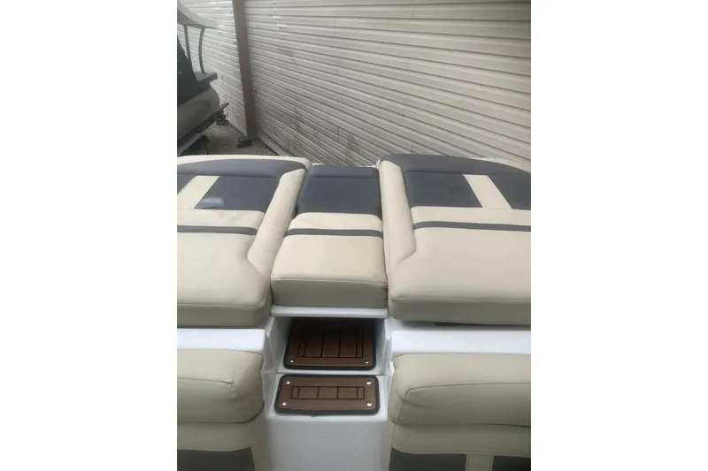 Slide: The Image of 2019 Rinker 29 QX boat with beige and gray cushioned seating. - 21