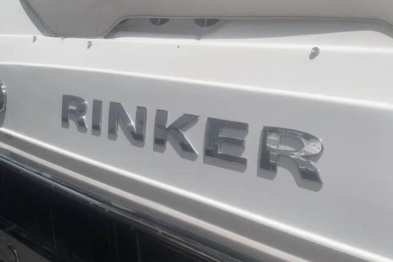 Slide: The Image of Chrome "Rinker" logo on a 2019 Rinker 29 QX boat hull. - 3