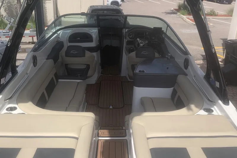Slide: The Image of 2019 Rinker 29 QX boat interior with beige seating and wood flooring. - 7