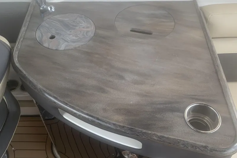 Slide: The Image of 2019 Rinker 29 QX boat interior with wooden countertop and cup holder. - 9