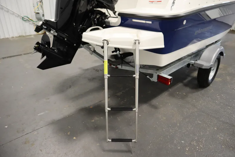 Slide: The Image of 2026 Bayliner Element E18 boat with ladder and trailer in a garage setting. - 28