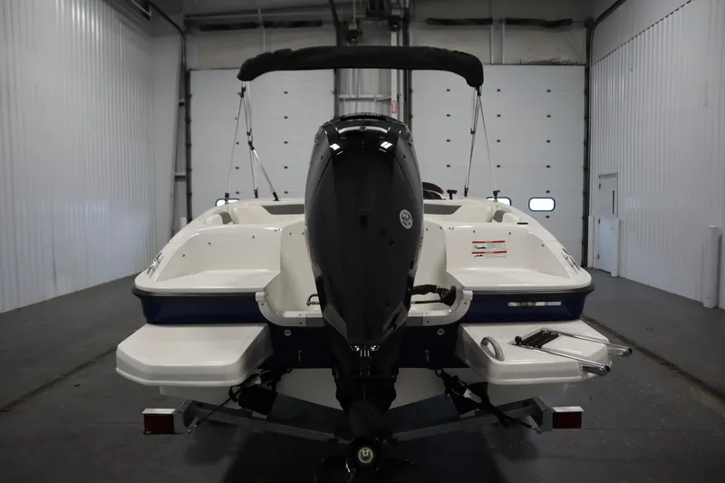Slide: The Image of 2026 Bayliner Element E18 boat in a garage, rear view with outboard motor. - 5