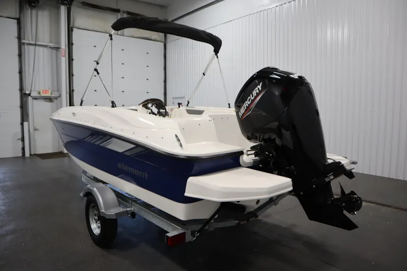 Slide: The Image of 2026 Bayliner Element E18 boat with Mercury outboard motor in a garage setting. - 6