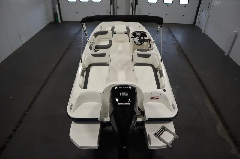 Slide: The Image of 2026 Bayliner Element E18 boat in indoor storage, featuring a Mercury 115 outboard motor. - 9