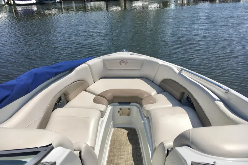 Slide: The Image of 2017 Crownline 275 SS boat interior with beige seating, docked on calm water. - 15
