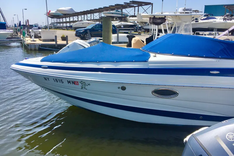 Slide: The Image of 2017 Crownline 275 SS boat docked with blue cover at marina. - 2
