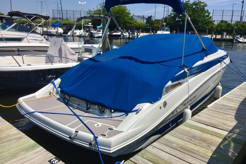 Slide: The Image of 2017 Crownline 275 SS boat docked, covered with a blue tarp, in a marina setting. - 3