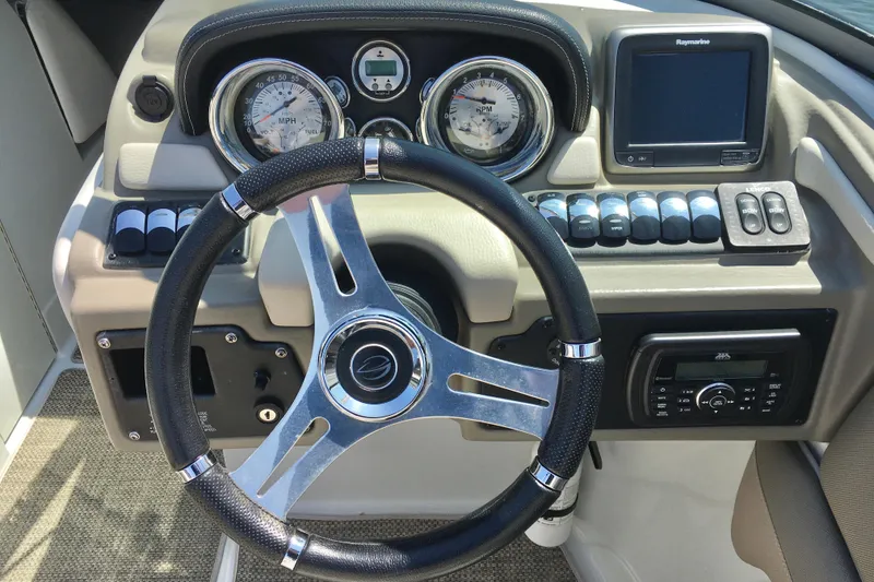Slide: The Image of Steering wheel and dashboard of 2017 Crownline 275 SS boat, featuring gauges and controls. - 7