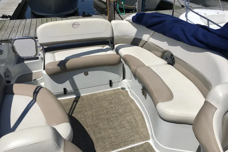 Slide: The Image of 2017 Crownline 275 SS boat interior with beige and white seating, docked at marina. - 9