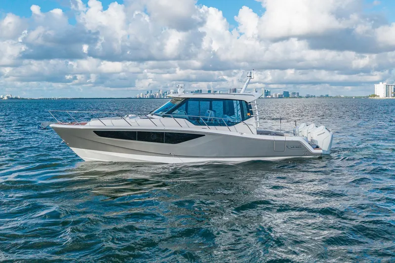 The Image of 2024 Boston Whaler 405 Conquest boat cruising on open water under a cloudy sky. - 0