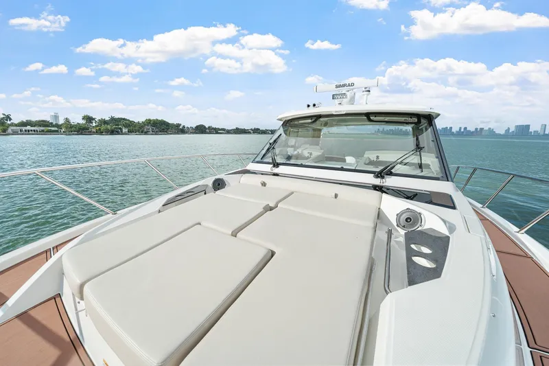 Slide: The Image of 2024 Boston Whaler 405 Conquest yacht on calm waters under a clear sky. - 11