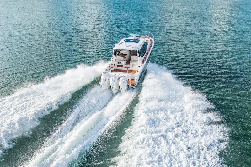 Slide: The Image of 2024 Boston Whaler 405 Conquest cruising on open water, rear view. - 2