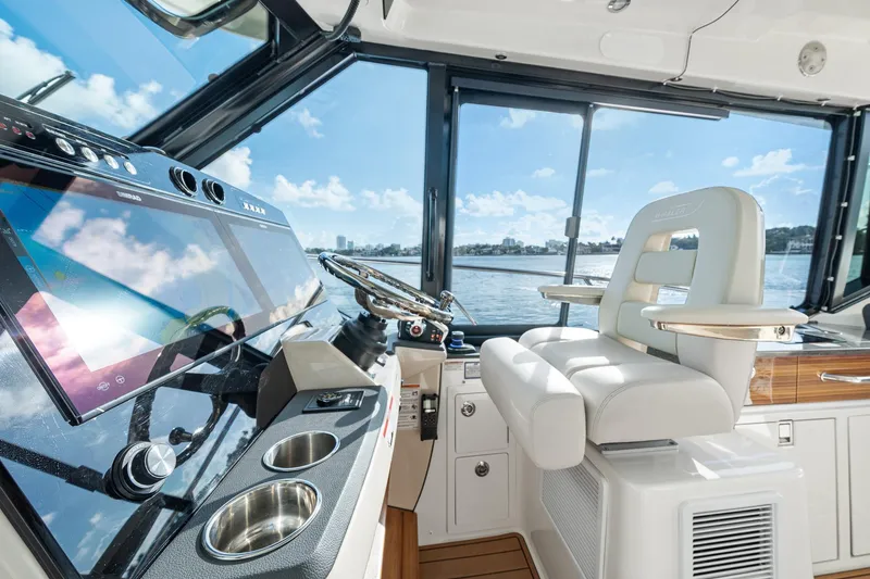 Slide: The Image of 2024 Boston Whaler 405 Conquest helm with modern controls and luxurious seating. - 24