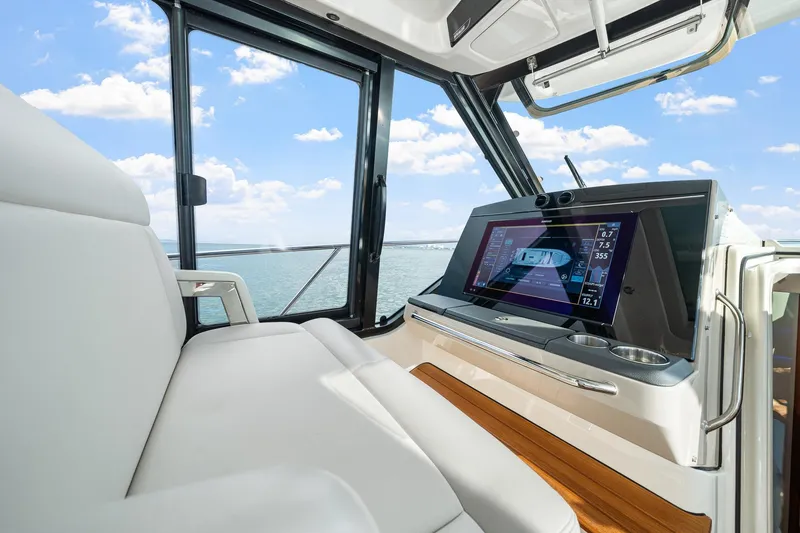 Slide: The Image of 2024 Boston Whaler 405 Conquest helm with advanced navigation display and comfortable seating. - 28