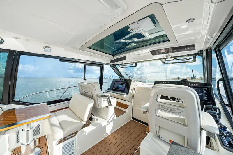 Slide: The Image of 2024 Boston Whaler 405 Conquest interior with modern helm, luxurious seating, and panoramic ocean view. - 30