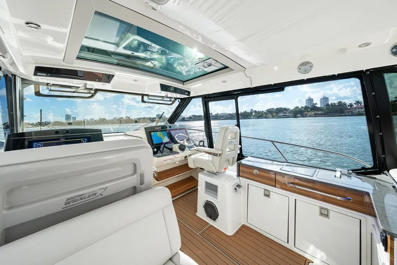 Slide: The Image of 2024 Boston Whaler 405 Conquest interior with modern helm and panoramic water views. - 35