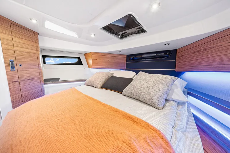 Slide: The Image of Luxurious cabin interior of 2024 Boston Whaler 405 Conquest with modern bedding and wood accents. - 43