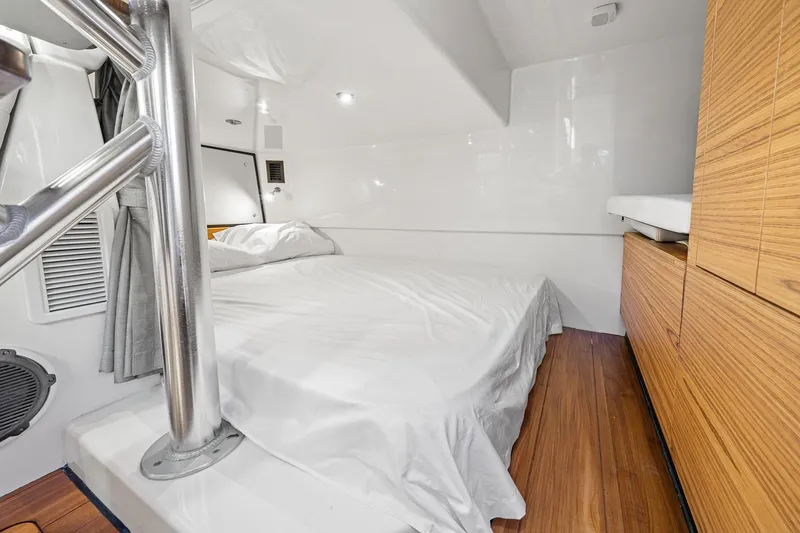 Slide: The Image of 2024 Boston Whaler 405 Conquest cabin interior with bed and wooden cabinetry. - 52