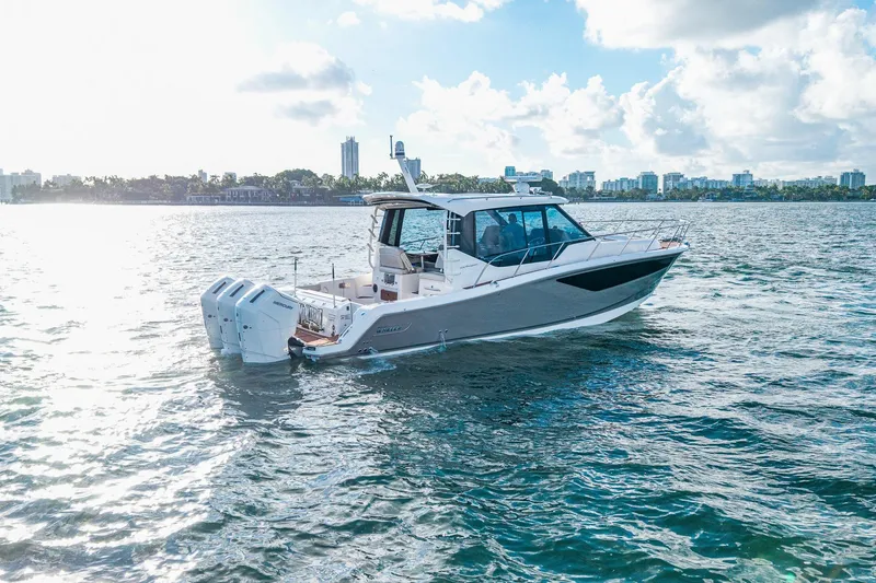 Slide: The Image of 2024 Boston Whaler 405 Conquest cruising on a sunny day, city skyline in background. - 57