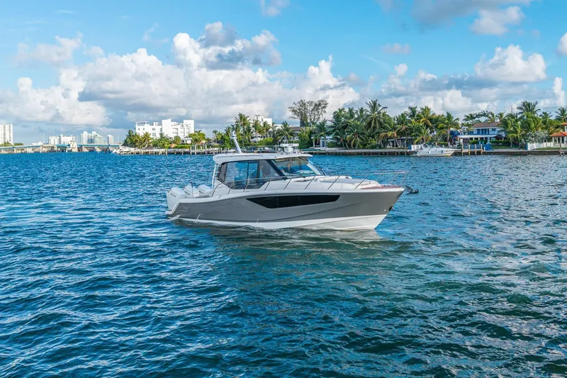 Slide: The Image of 2024 Boston Whaler 405 Conquest cruising on a scenic, tropical waterway. - 6