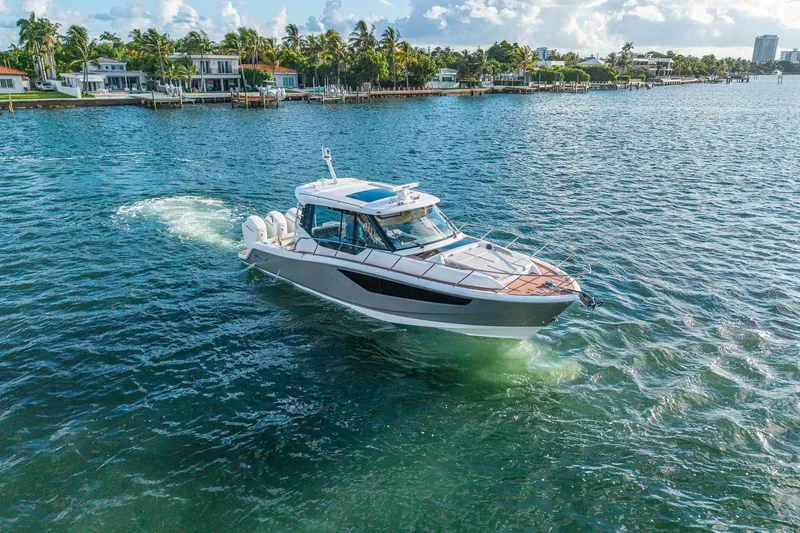 Slide: The Image of 2024 Boston Whaler 405 Conquest cruising on a sunny day near waterfront homes. - 60