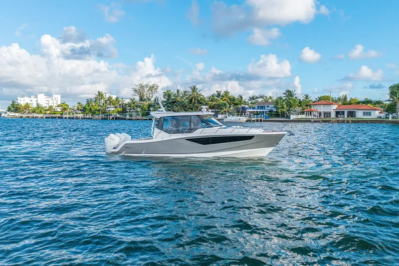 Slide: The Image of 2024 Boston Whaler 405 Conquest cruising on a sunny day near waterfront homes. - 62