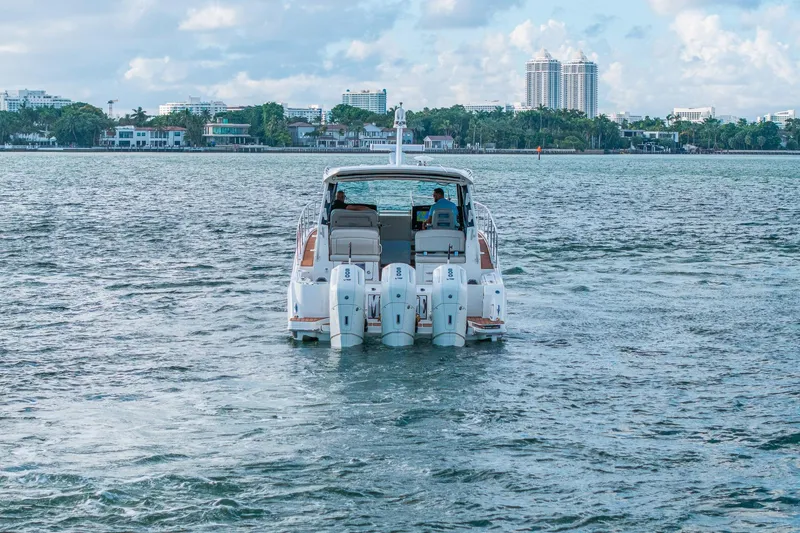 Slide: The Image of 2024 Boston Whaler 405 Conquest cruising on a scenic waterway with city skyline. - 66