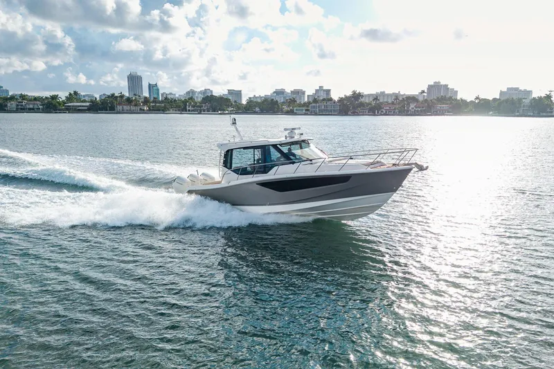 Slide: The Image of 2024 Boston Whaler 405 Conquest cruising on a sunny day near city skyline. - 71