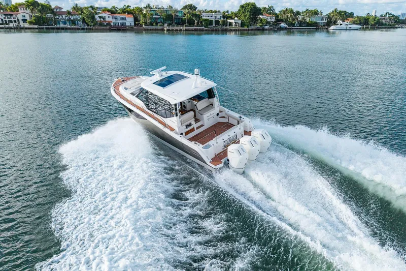 Slide: The Image of 2024 Boston Whaler 405 Conquest cruising on a scenic waterway, showcasing powerful engines. - 8