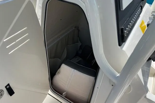 Slide: The Image of 2026 Key West 219 FS boat storage compartment with cushion inside. - 8