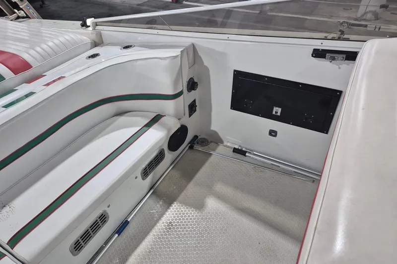 Slide: The Image of Interior of a 1982 Magnum 40 boat with white seating and green-red accents. - 17