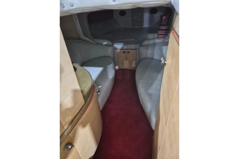 Slide: The Image of Interior of a 1982 Magnum 40 boat, featuring red carpet and curved seating. - 29