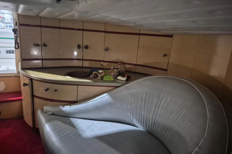 Slide: The Image of 1982 Magnum 40 yacht interior with curved seating and compact kitchenette. - 32